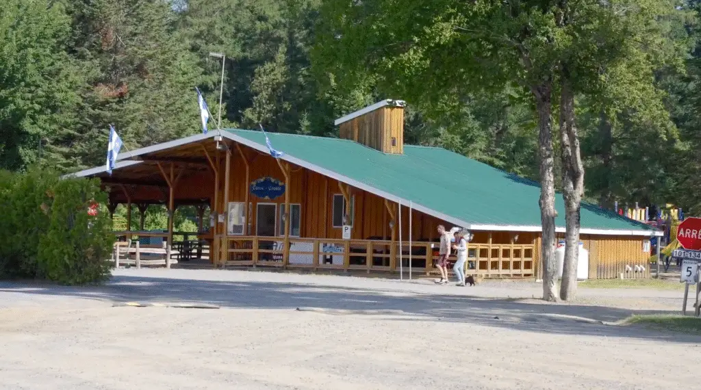 a building with a green roof and people walking by