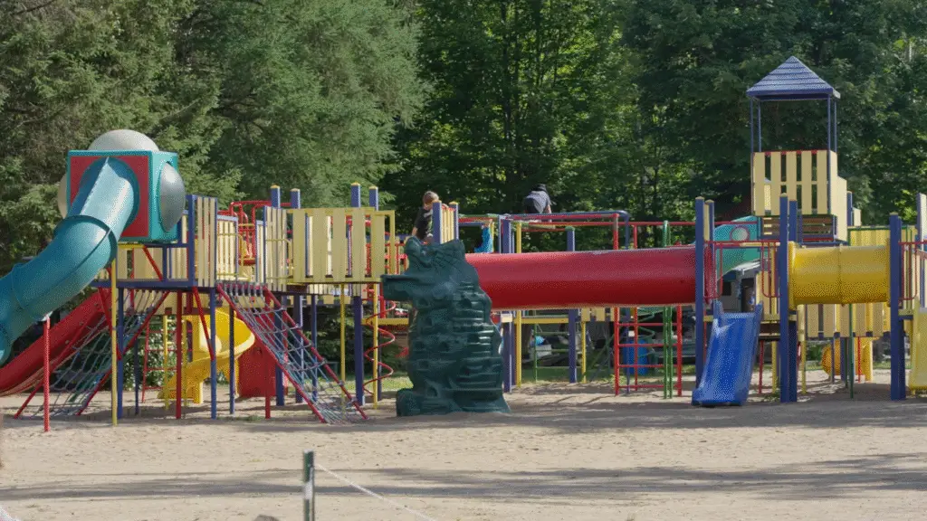 a playground with a red tube and a red slide